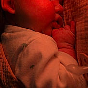 Luna joined the competition — help win amazing prizes! baby, sleeping, infant, red_light, blanket, closeup, hand, face, peaceful, cozy, soft_texture, portrait, indoors, cute, newborn, resting, warm_tone, clothing, child, quiet