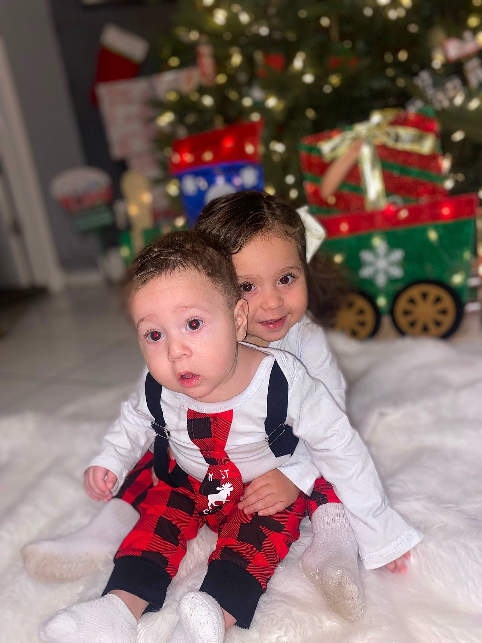 Avian is registered to the contest to win money with this photo: baby, baby_toddler_clothing, child, christmas_tree, event, eye, face, facial_expression, fun, happy, head, joy, mammal, people, person, photograph, red, sleeve, smile, surprise