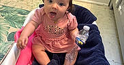 Aviana joined the competition — help win amazing prizes! baby, baby_seat, blanket, cabinet, child, cute, expression, floor_mat, green_wall, hair_ties, home, indoor, infant, person, pink_clothing, playful, portrait, sitting, tongue_out, water_bottle
