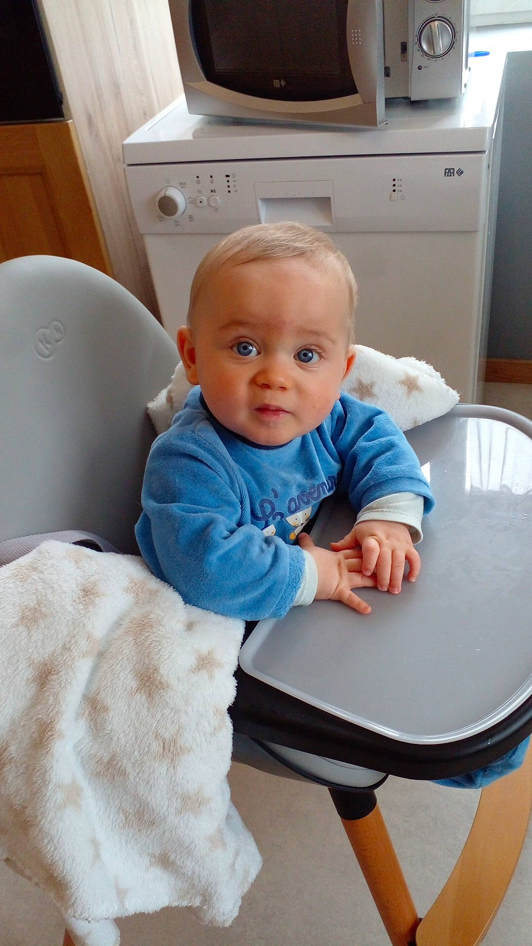 Tyméo participe au concours pour gagner de l'argent avec cette photo : baby, baby_toddler_clothing, cabinetry, chair, child, comfort, cooktop, drawer, electric_blue, floor, flooring, kitchen_appliance, kitchen_stove, person, room, sitting, sleeve, surprise, t_shirt, table