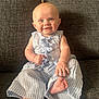 baby, infant, smiling, sitting, blue_striped_clothing, barefoot, couch, indoors, child, happy, cute, portrait, one_person, young_child, face, human, skin, furniture, casual, relaxed