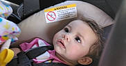 Ellie is registered to the contest to win money with this photo: baby, child, car_seat, seatbelt, interior, car, window, face, curious, clothing, blanket, young_child, infant, safety, portrait, seat, looking, daylight, expression, young