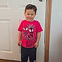 Michael is registered to the contest to win money with this photo: barefoot, casual_clothing, child, cute, door, graphic_tee, happy, home, indoors, navy_pants, person, red_tshirt, short_hair, smiling, spiderman, standing, toddler, white_door, wood_floor, young