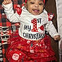 Alasia is registered to the contest to win money with this photo: baby, child, smiling, christmas, holiday, festive_clothing, red_headband, white_shirt, red_skirt, santa_claus_pattern, blanket, happy, cute, infant, lying_down, indoors, celebration, festive, toddler, holiday_season