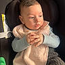 Adan participe au concours pour gagner de l'argent avec cette photo : baby, child, car_seat, bib, knitted_pants, hands, face, portrait, indoor, seatbelt, sunlight, clothing, expression, infant, cute, young_child, sitting, casual, looking_away, warm_light