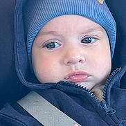 Adan a rejoint le concours — aidez-le/la à gagner de superbes lots ! baby, child, blue_hoodie, blue_beanie, car_seat, seatbelt, face, hand, clothing, portrait, infant, cute, expression, indoor, person, young_child, closeup, warm_clothing, casual, sitting