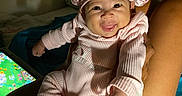 Mai joined the competition — help win amazing prizes! baby, bed, blanket, bonnet, child, cute, furniture, hand, happy, home, indoor, infant, legs, person, pink_pajamas, portrait, screen, smiling, tablet, tongue_out