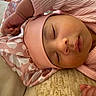 baby, sleeping, pink_clothing, hat, infant, peaceful, soft_fabric, closeup, child, resting, cute, indoors, portrait, cozy, skin, headwear, peace, relaxation, small_hand, face