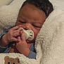 Elias a rejoint le concours — aidez-le/la à gagner de superbes lots ! baby, infant, pacifier, blanket, teddy_bear, hand, face, sleepy, cozy, fur_texture, blue_clothing, newborn, cute, soft, child, portrait, indoors, resting, wrapped, warm