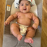 Sam is registered to the contest to win money with this photo: baby, infant, diaper, baby_seat, hat, chubby, drool, wooden_floor, curious, cushion, child, cute, plump, relaxed, indoors, smile, skin, person, apparel, comfortable