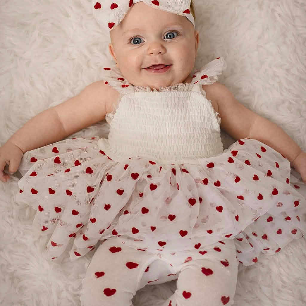 Hazel is registered to the contest to win money with this photo: adorable, baby, blue_eyes, bow, child, cute, fashion, fluffy_background, happy, headband, heart_pattern, infant, leggings, lying_down, playful, portrait, smiling, soft_texture, tutu, white_clothing