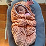 baby, blanket, sleeping, infant, baby_rocker, toy, soft_texture, peaceful, indoor, floor, tiled_floor, child, wrapped, cozy, pink, gray, plush, head, resting, cute