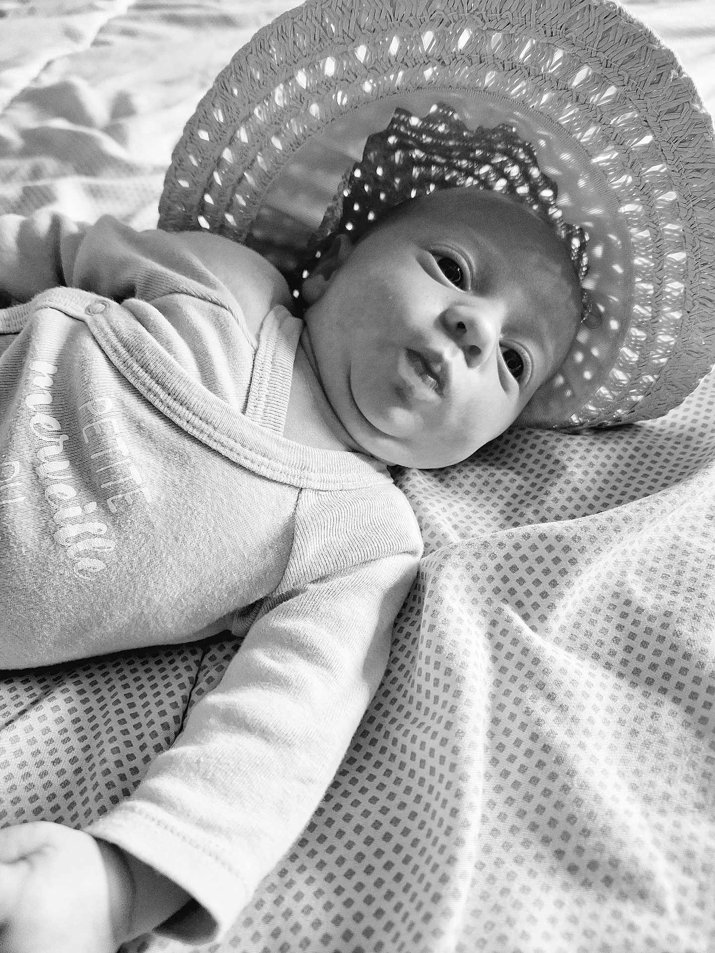 Lilou participe au concours pour gagner de l'argent avec cette photo : baby, infant, hat, woven_hat, blanket, patterned_blanket, face, pout, expression, black_and_white, portrait, lying_down, clothing, long_sleeve, cute, child, skin, newborn, soft_light, shadow