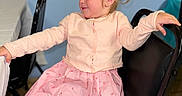 Oakley joined the competition — help win amazing prizes! black_chair, blonde_hair, cardigan, chair, child, floor, furniture, girl, happy, indoor, person, pink_dress, ponytail, portrait, smiling, stained_glass, table, tablecloth, toddler, wall