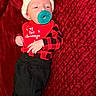 Carson joined the competition — help win amazing prizes! baby, infant, pacifier, hat, knitted_hat, red_blanket, plaid_clothing, bib, christmas, holiday, cute, sleeping, child, newborn, black_pants, red, festive, cozy, portrait, indoors