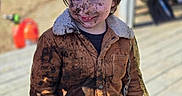 Tatum is registered to the contest to win money with this photo: adventure, casual, child, clothing, daylight, dirt, dirty, face, fun, happy, jacket, messy, mud, nature, outdoor, person, play, smiling, wooden_deck, young
