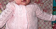 Lyla is registered to the contest to win money with this photo: baby, child, pink, headband, blanket, pattern, clothing, cute, infant, portrait, smile, face, lying_down, indoor, soft_texture, knitwear, young, happy, closeup, adorable