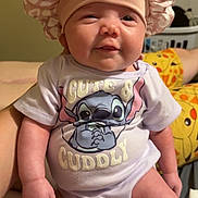 Katalina is registered to the contest to win money with this photo: baby, infant, child, cute, onesie, clothing, hat, bonnet, pink, face, smile, sitting, person, human, indoor, portrait, soft_lighting, cute_and_cuddly, stitch_character, baby_hand