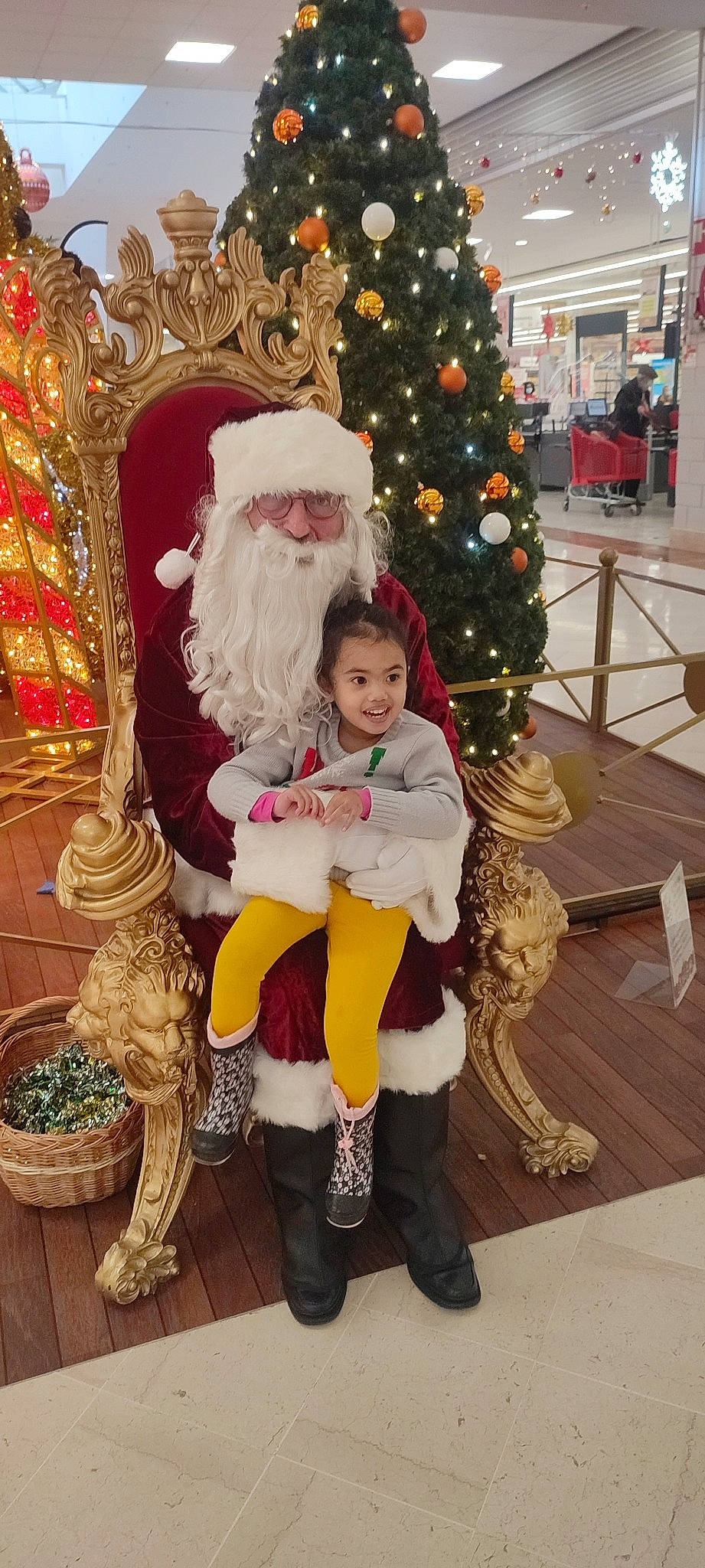 Nalya a rejoint le concours — aidez-le/la à gagner de superbes lots ! beard, chair, christmas_decoration, christmas_tree, event, flowerpot, fun, happy, head, holiday, houseplant, human_body, joy, lap, leg, person, plant, santa_claus, sitting, toddler