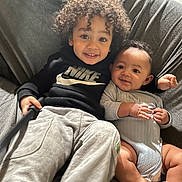 Tayvion And Lamar is registered to the contest to win money with this photo: child, baby, couch, smile, curly_hair, hoodie, clothing, indoor, person, happy, infant, toddler, cute, sitting, family, relaxing, skin, foot, hand, portrait