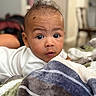 Legend is registered to the contest to win money with this photo: baby, infant, face, eyes, hair, blanket, indoor, closeup, portrait, child, curious, soft_light, expression, person, couch, furniture, skin, young, cute, lying_down