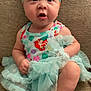 Kayliese is registered to the contest to win money with this photo: baby, child, headband, dress, frills, sitting, couch, footwear, sandals, curious, expression, indoors, fabric, colorful, cute, toddler, person, portrait, texture, soft
