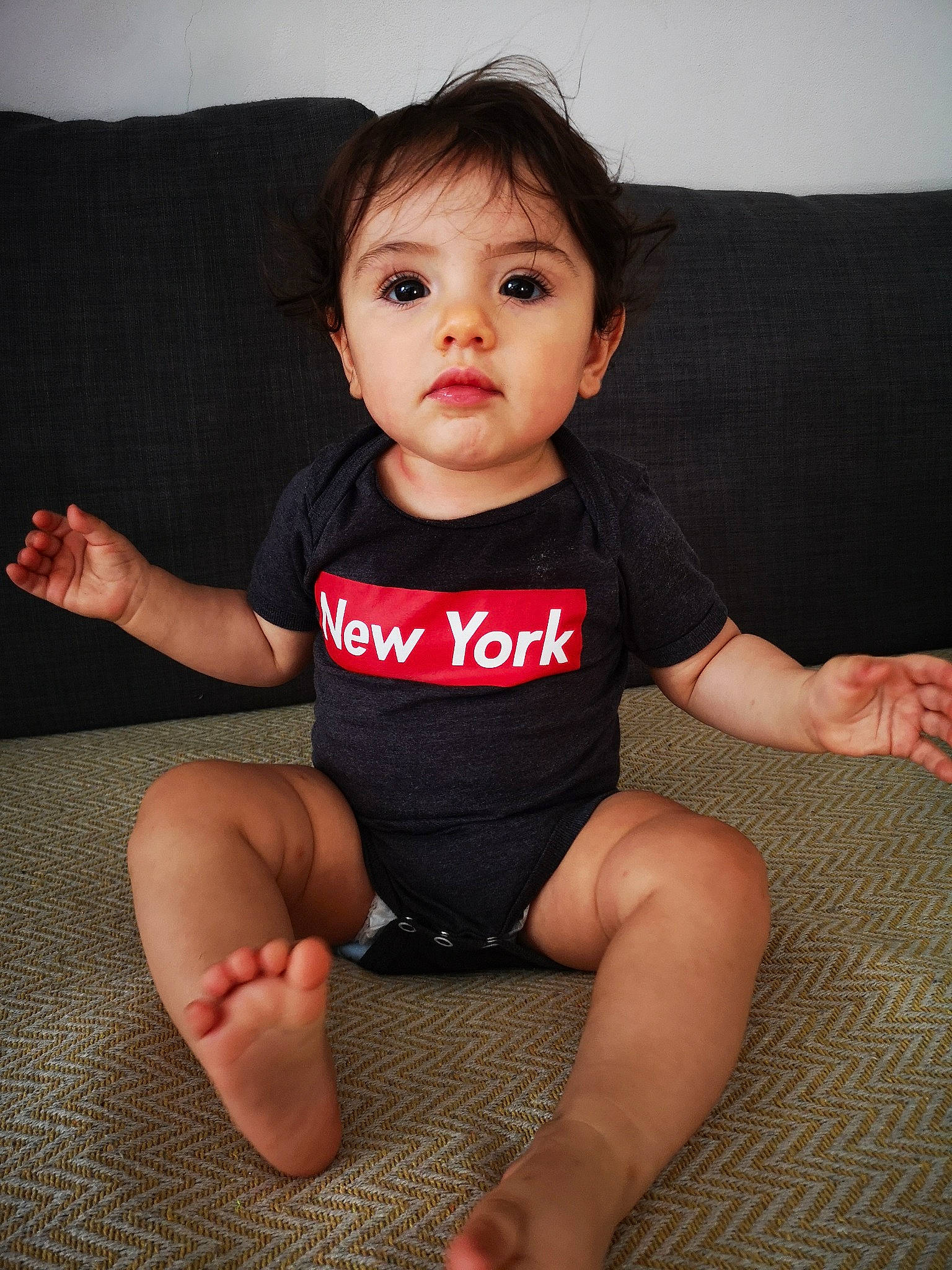 Ema participe au concours pour gagner de l'argent avec cette photo : baby_toddler_clothing, cheek, comfort, elbow, face, finger, flash_photography, gesture, hand, head, human_body, joint, knee, leg, neck, person, shoulder, skin, sleeve, t_shirt