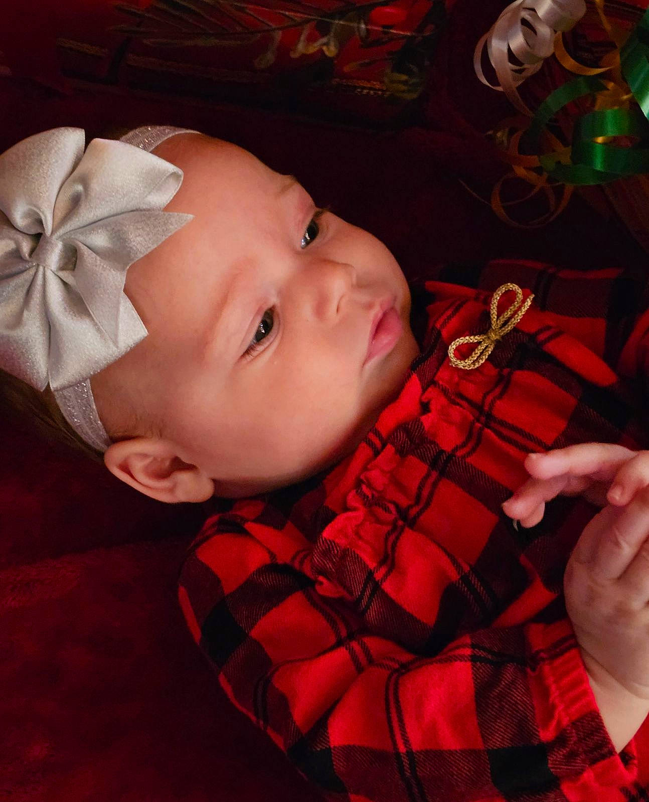 River is registered to the contest to win money with this photo: baby, baby_toddler_clothing, beauty, cheek, child, collar, event, head, lip, nose, pattern, person, pink, plaid, red, skin, sleeve, tartan, textile, toddler
