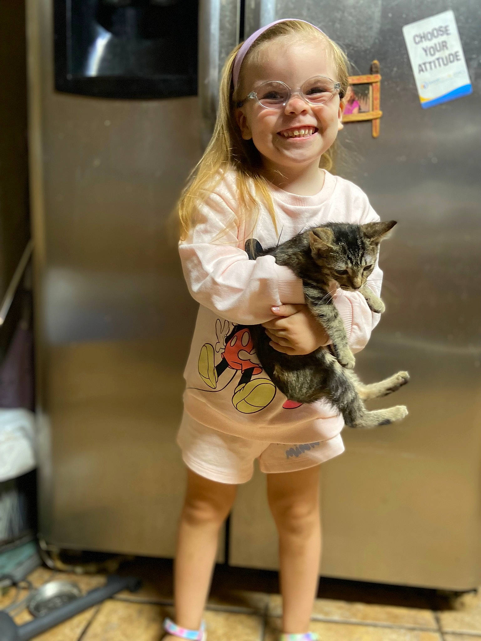 Braelyn is registered to the contest to win money with this photo: brown_hair, carnivore, cat, fawn, felidae, flooring, fur, glasses, hair, human_leg, joy, long_hair, person, picture_frame, skin, sleeve, small_to_medium_sized_cats, smile, television, thigh