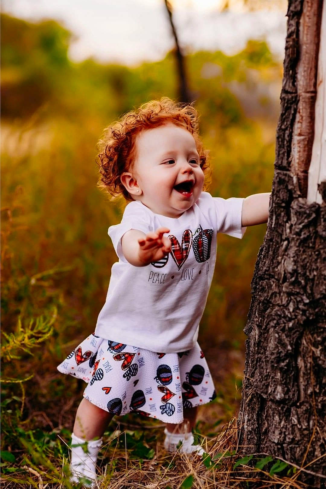 Braelee joined the competition — help win amazing prizes! baby, baby_toddler_clothing, beauty, child, eye, facial_expression, flash_photography, grass, happy, leaf, nature, people_in_nature, person, plant, smile, summer, sunlight, toddler, tree, trunk