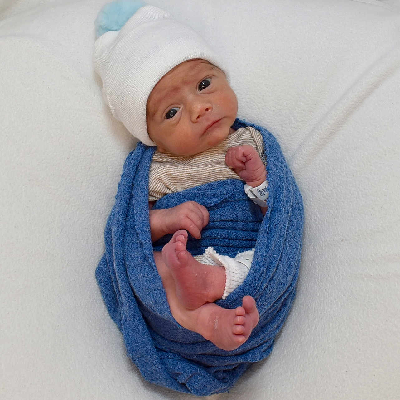 Weston joined the competition — help win amazing prizes! baby, bed, blanket, bodypart, bonnet, cap, clothing, couch, face, finger, furniture, hand, hat, head, newborn, person, photography, portrait, quilt, towel