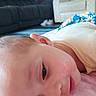 baby, infant, child, face, eyes, lying_down, indoors, blanket, pink_blanket, living_room, sofa, armchair, clothing, portrait, close_up, looking_at_camera, awake, skin, head, cozy