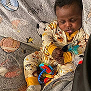 Kaizen is registered to the contest to win money with this photo: baby, sleeping, pajamas, blanket, toy, infant, child, cozy, cute, patterned, animal_print, resting, hands, footwear, indoor, portrait, peaceful, soft, comfort, nap