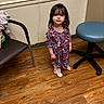 bangs, brown_hair, candid, chair, child, countertop, curious, cute, floral_dress, hardwood_floor, indoor, little_girl, medical_chair, person, socks, standing, stool, toddler, waiting_room, wall