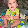 Nehemiah joined the competition — help win amazing prizes! baby, child, toys, rattle, onesie, smiling, indoor, blanket, plush, sitting, happy, face, person, infant, cute, home, colorful, play, couch, pacifier