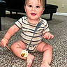 baby, smiling, striped_onesie, pacifier, carpet, sitting, indoor, child, furniture, wall, floor, happy, person, cute, infant, playful, head, hand, foot, toy