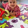 baby, child, smiling, toy, colorful_mat, indoor, floor, play, pink_clothing, happy, portrait, face, hands, head, infant, cute, home, puzzle_mat, early_learning, toddler