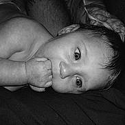 Gabriella joined the competition — help win amazing prizes! baby, black_and_white, child, closeup, curious, cute, expression, face, fist, hand, infant, innocence, lying_down, monochrome, portrait, relaxing, skin, soft_lighting, sucking, young_child