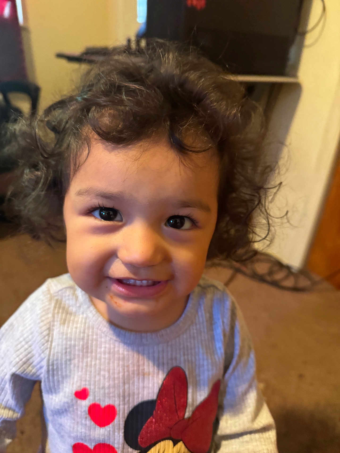 Analei is registered to the contest to win money with this photo: carpet, casual, child, closeup, clothing, curly_hair, cute, face, happy, home, indoor, minnie_mouse, person, portrait, red_hearts, smiling, sweater, toddler, warm_light, young_child
