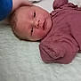 Payton is registered to the contest to win money with this photo: baby, infant, newborn, bed, blanket, hand, clothing, mauve, soft, portrait, face, person, sleepwear, bedroom, rest, lying_down, cute, skin, young, tender