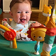 Zander is registered to the contest to win money with this photo: baby, child, smiling, happy, indoor, toys, activity_center, colorful, face, cute, infant, play, furniture, floor, clothing, person, home, bright, joyful, seat