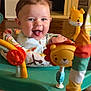 baby, child, smiling, happy, indoor, toys, activity_center, colorful, face, cute, infant, play, furniture, floor, clothing, person, home, bright, joyful, seat