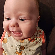 Coleson joined the competition — help win amazing prizes! baby, infant, face, smile, tongue, cute, clothing, winnie_the_pooh, cartoon, button, orange, yellow, person, child, closeup, portrait, indoor, happy, young, sitting