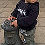 Tiago participe au concours pour gagner de l'argent avec cette photo : bench_hoodie, casual, chairs, child, clothing, curious, daylight, hands, metal_post, outdoor, patio, pavement, people, public_space, side_view, sneakers, standing, tables, toddler, urban