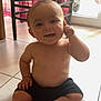 baby, bare_chest, chair, child, curtain, floor, foot, furniture, hand, happy, home, indoor, interior, natural_light, person, shorts, sitting, smiling, tile, window