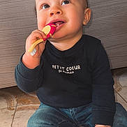 Noé participe au concours pour gagner de l'argent avec cette photo : baby, child, toothbrush, floor, jeans, black_shirt, sitting, happy, curious, indoor, tiled_floor, cute, hand, face, person, smiling, young_child, hair, footwear, clothing