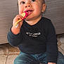baby, child, toothbrush, floor, jeans, black_shirt, sitting, happy, curious, indoor, tiled_floor, cute, hand, face, person, smiling, young_child, hair, footwear, clothing