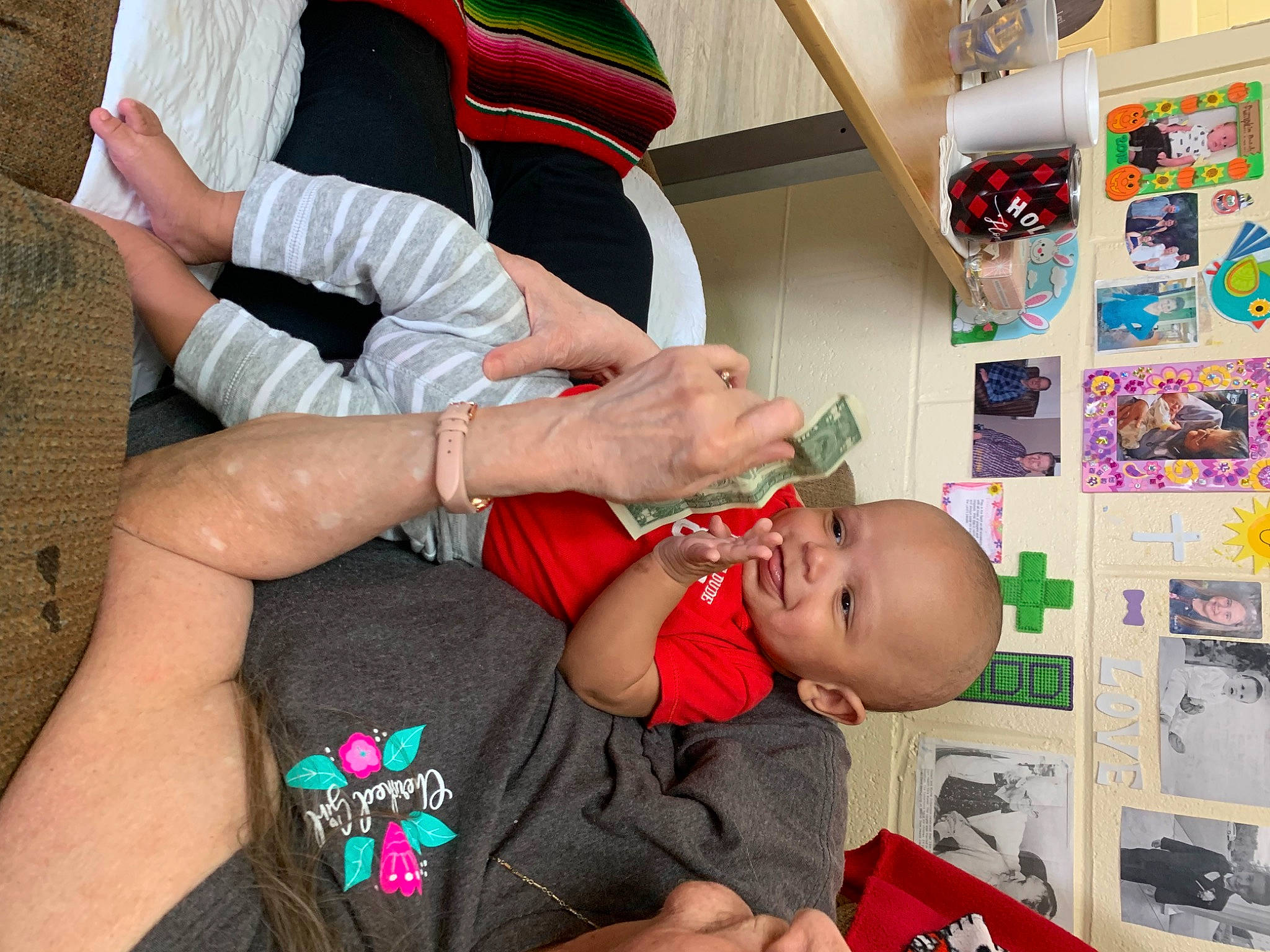 Zavian is registered to the contest to win money with this photo: baby, blurred, child, comfort, elbow, event, finger, fun, gesture, hand, happy, hat, human_leg, joy, lap, nail, person, sitting, t_shirt, thigh