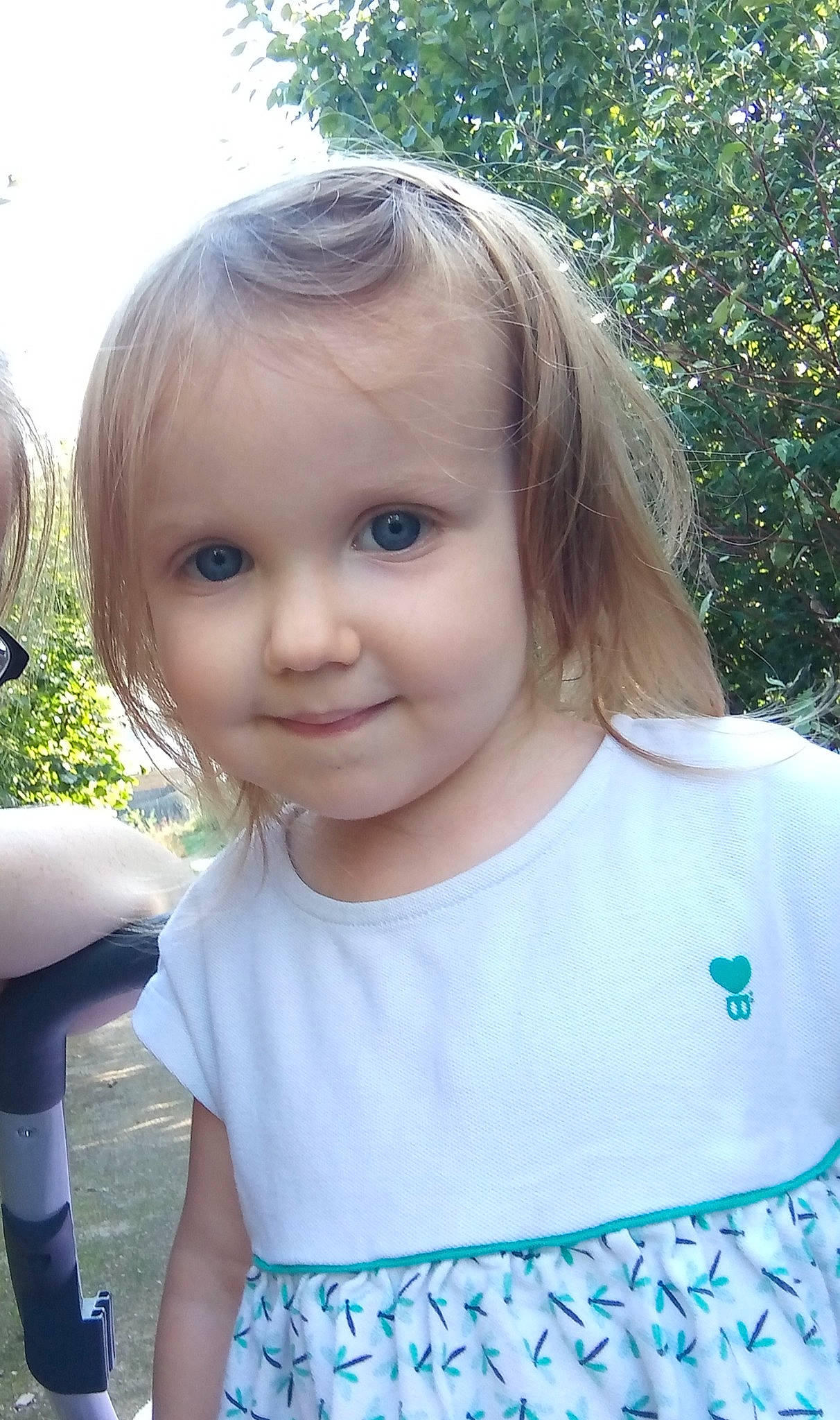 Maelys participe au concours pour gagner de l'argent avec cette photo : baby_toddler_clothing, bangs, blond, child, electric_blue, eye, eyelash, fun, grass, happy, iris, joy, leisure, lip, person, skin, sleeve, smile, summer, t_shirt