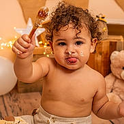 Kyle participe au concours pour gagner de l'argent avec cette photo : balloon, birthday, cake, celebration, child, curly_hair, cute, decoration, face, frosting, happy, indoors, messy, person, smiling, string_lights, teddy_bear, toddler, wooden_floor, wooden_spoon